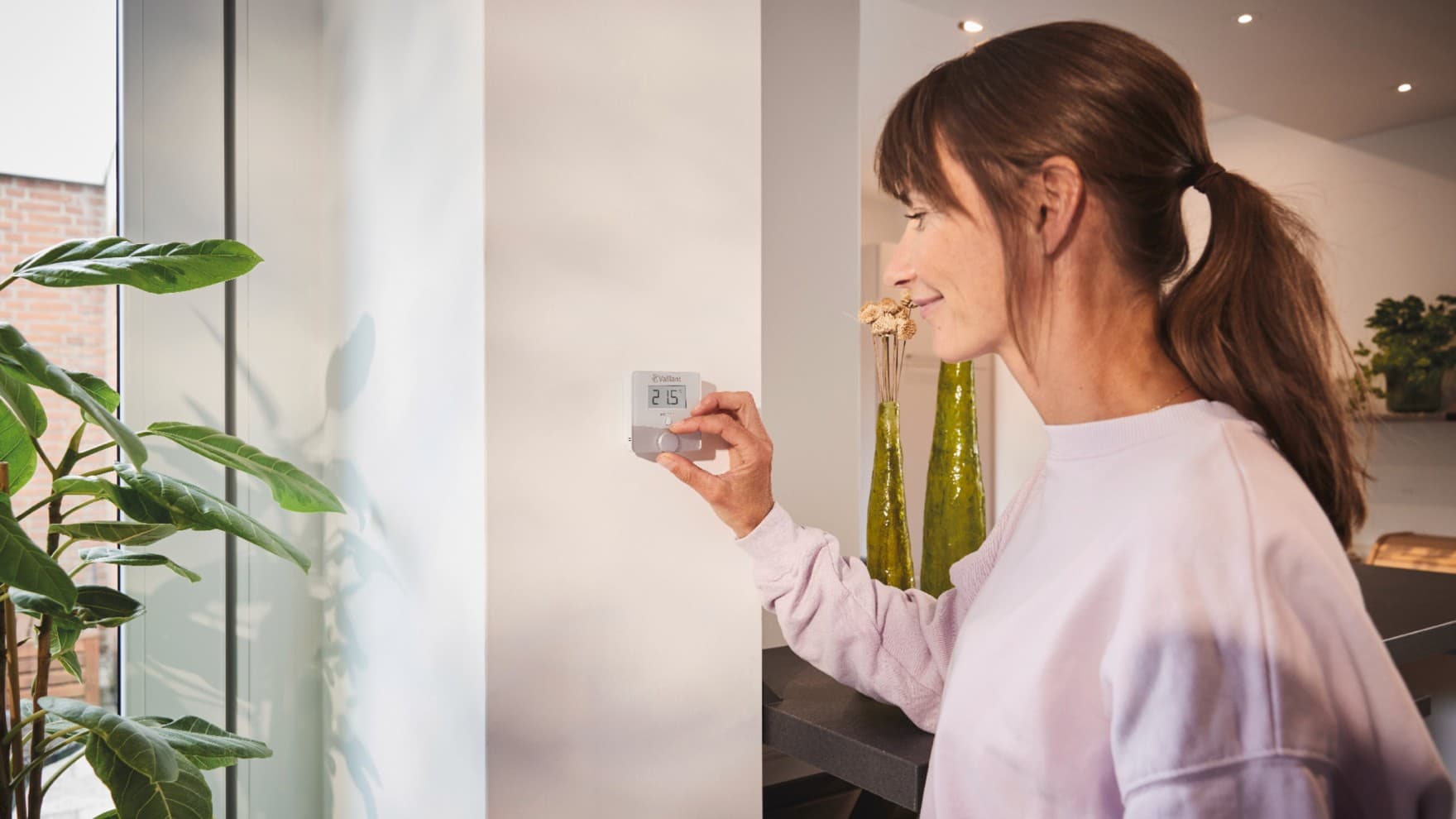 Žena používajúca termostat Vaillant sensoROOM