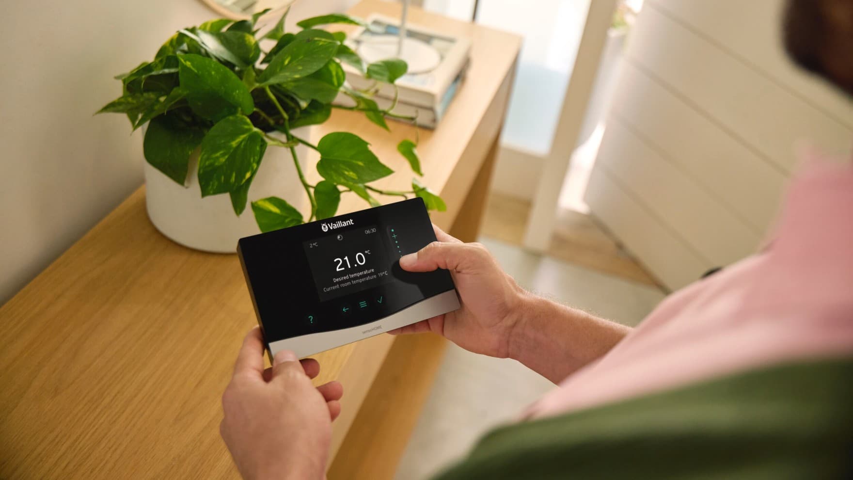 Muž držiaci v ruke ovládací panel Vaillant