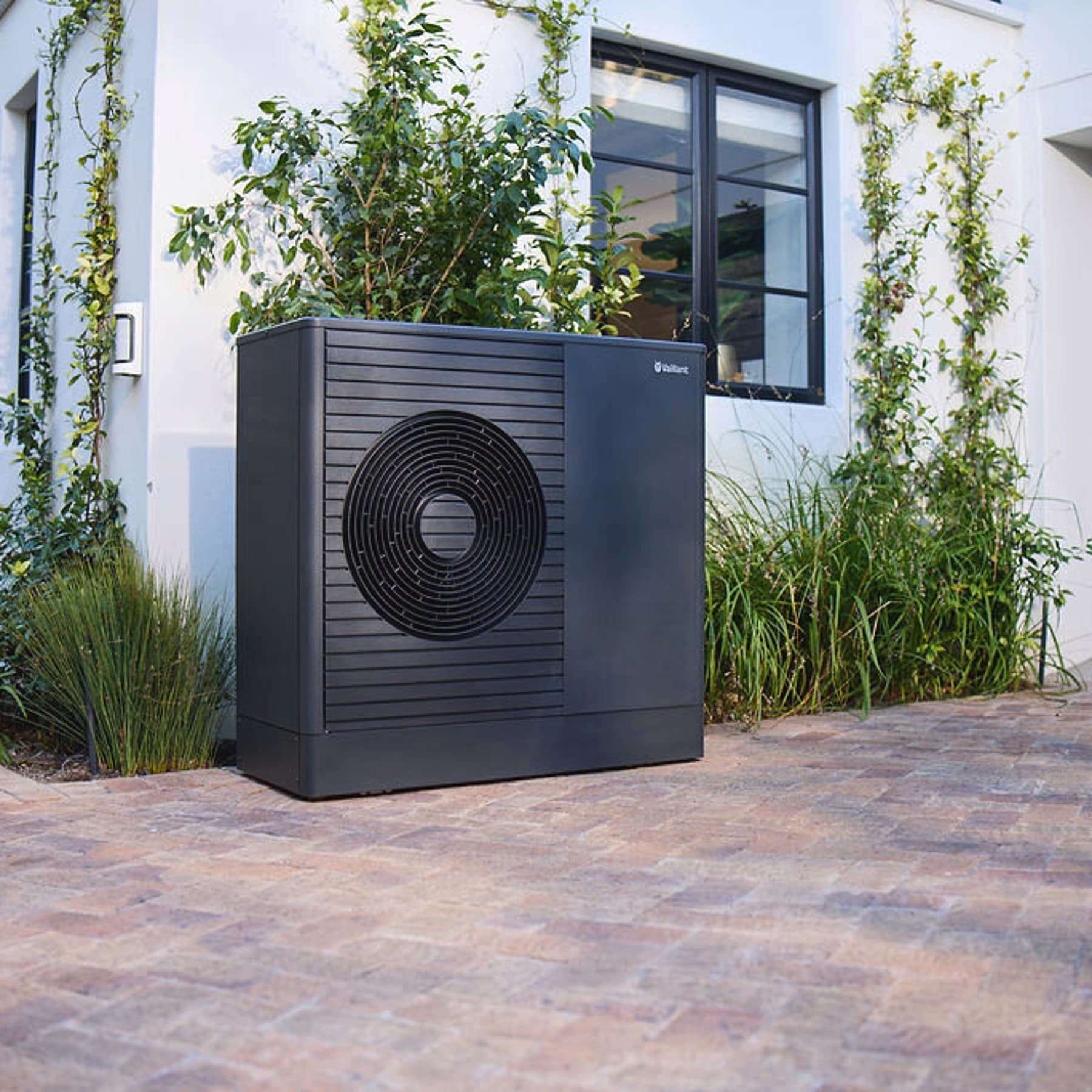 Antracitové tepelné čerpadlo Vaillant aroTHERM plus v prednej záhrade domu