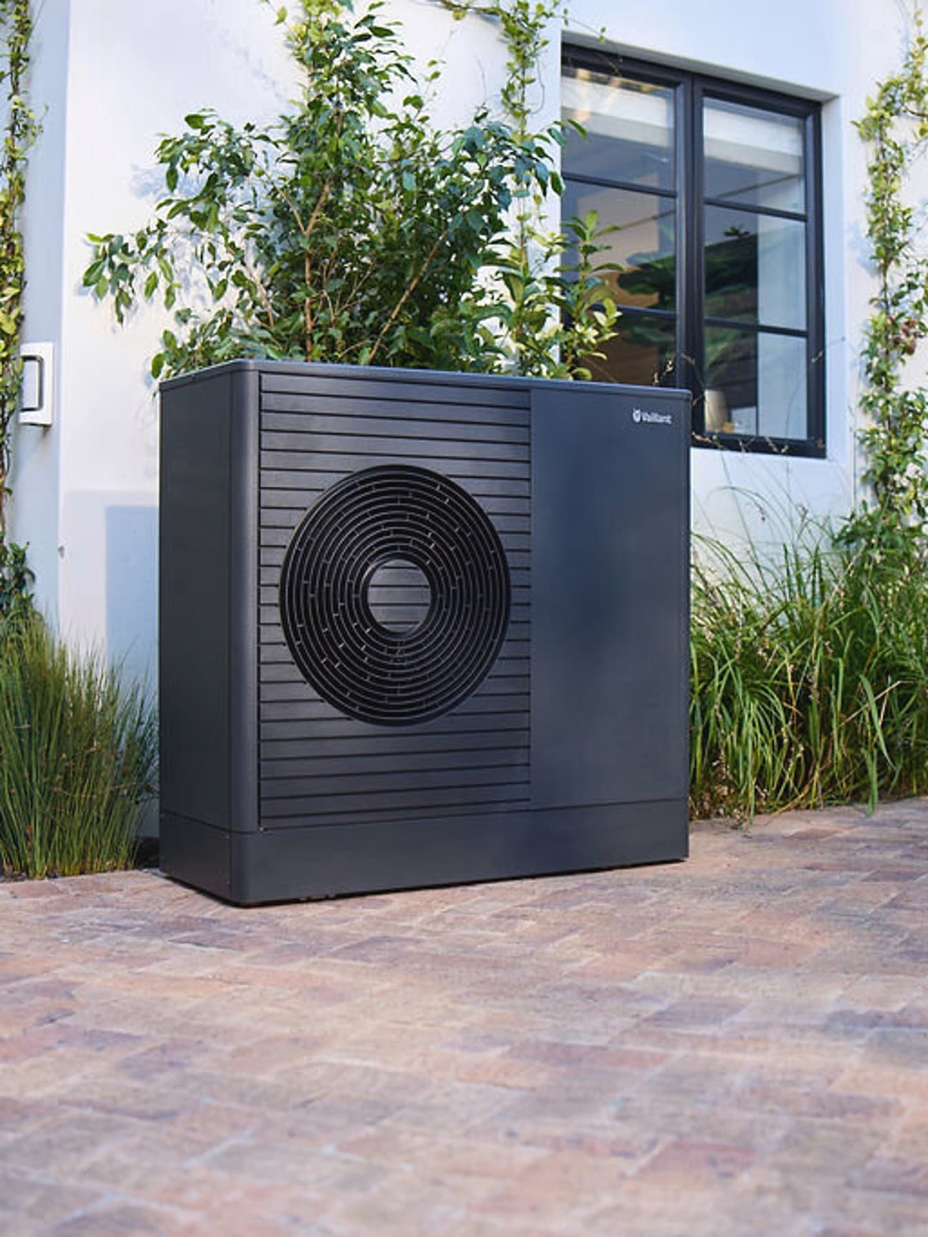 Antracitové tepelné čerpadlo Vaillant aroTHERM plus v prednej záhrade domu