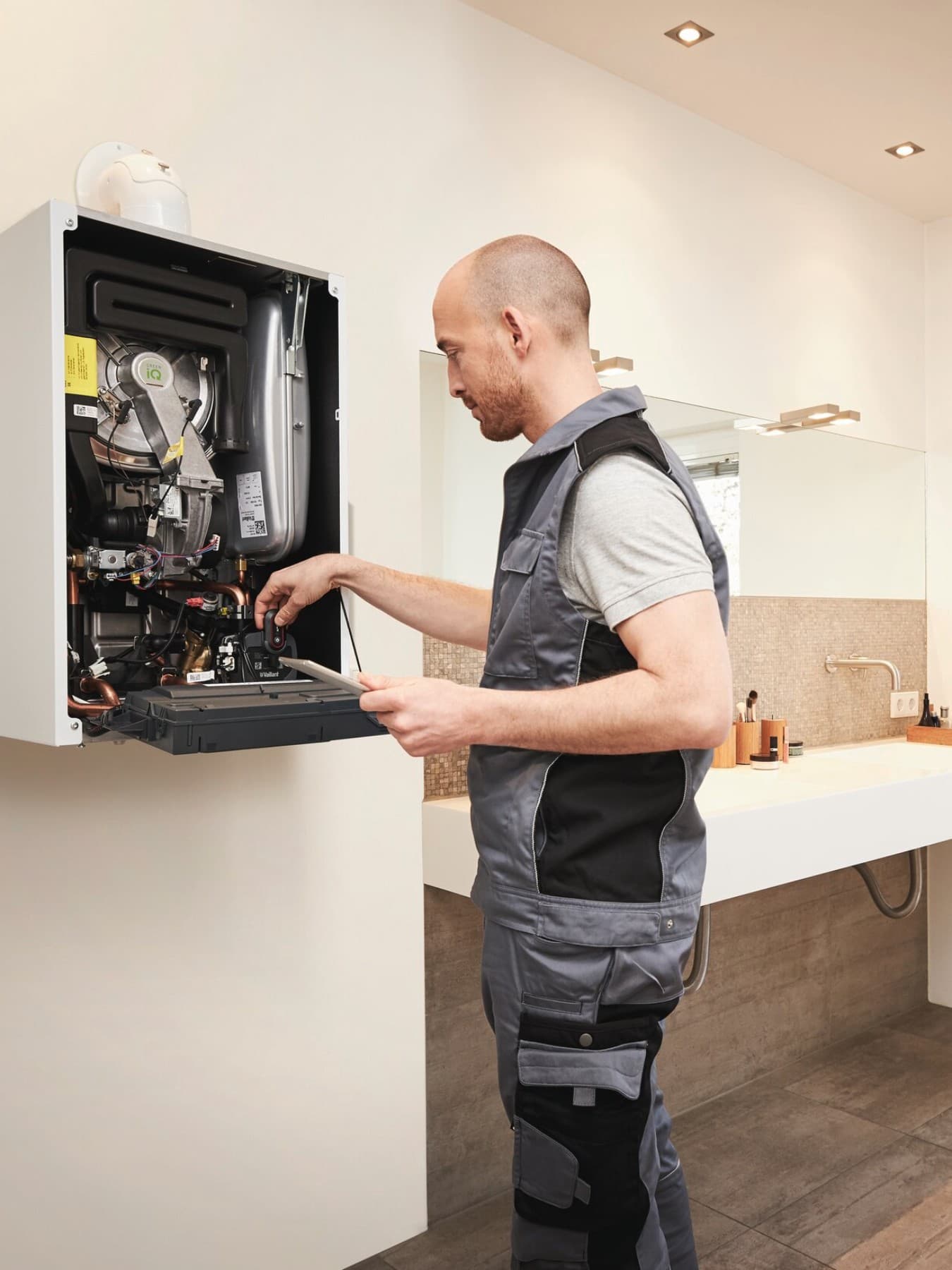 Servisný technik opravuje plynový kotol na stene v kúpeľni