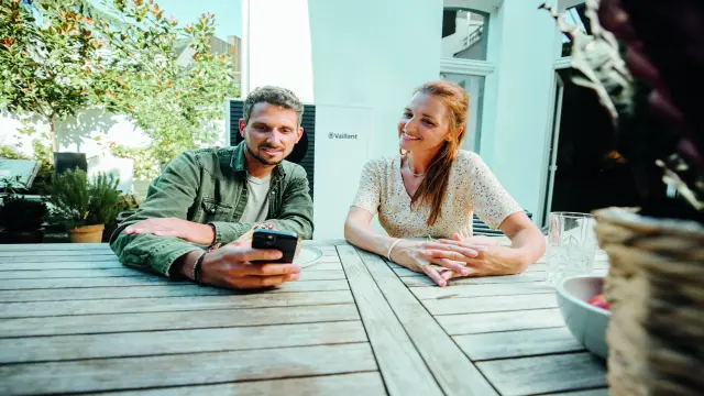 Mladí manželia pozerajú spolu do mobilu