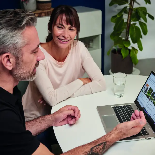 Manželia si prezerajú webové stránky na notebooku